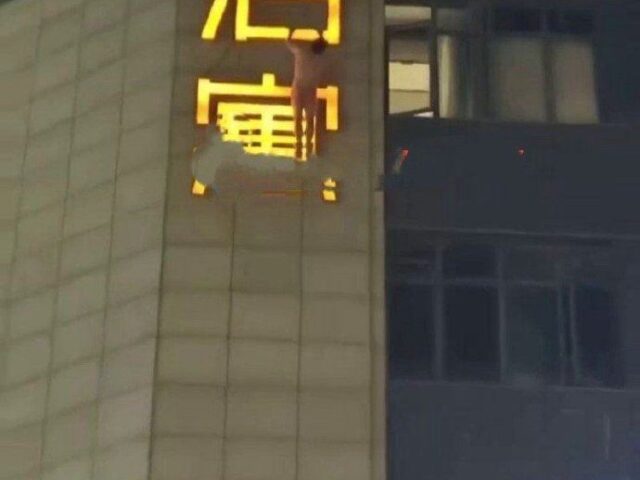 台灣新聞通訊社-玩到一半被抓姦？裸男深夜爬上酒店外招牌　街上民眾全拍下