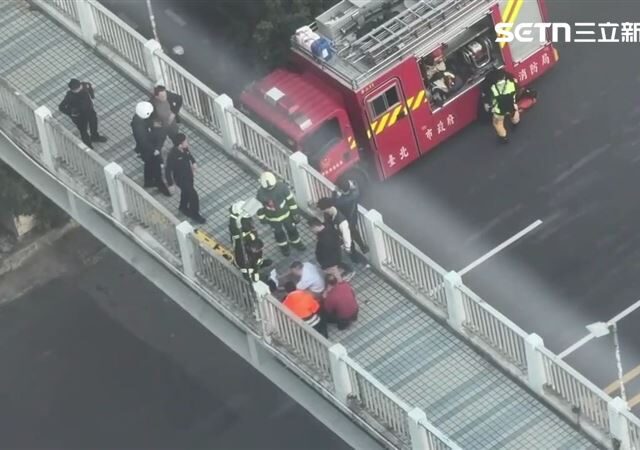 台灣新聞通訊社-一度懸在半空中！抗議常客北車前跳陸橋　4警消及時抓住手腳拉回