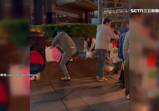 台灣新聞通訊社-台北101前有發財水？民眾直擊一群人晚間瘋舀水