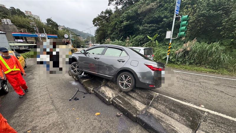 台灣新聞通訊社-基隆小客車打滑失控！暴衝自撞「騎上護欄」卡半空　駕駛幸運逃過一劫