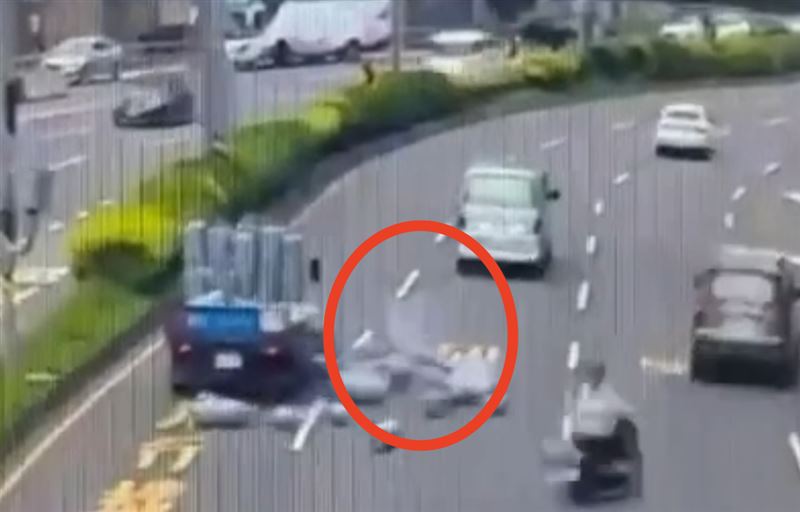 台灣新聞通訊社-驚險畫面曝！貨車急轉…數十瓦斯桶摔路面「滾圈噴白煙」駕駛叼菸搶救