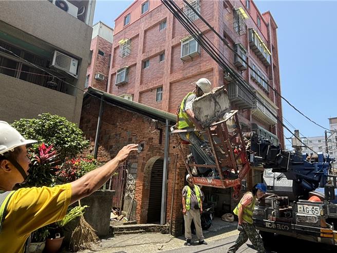 台灣新聞通訊社-淡水公寓外牆崩 鋼筋裸露「懸半空」新北市府急派吊車拆塊體