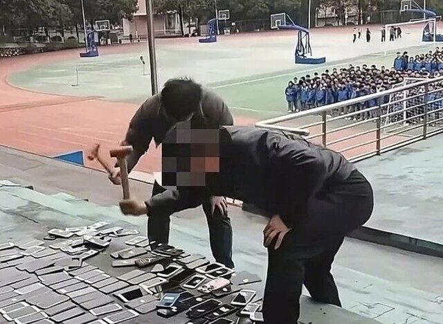 台灣新聞通訊社-鐵鎚教育？湖南某中學「殺雞儆猴」  公開砸毀百支手機