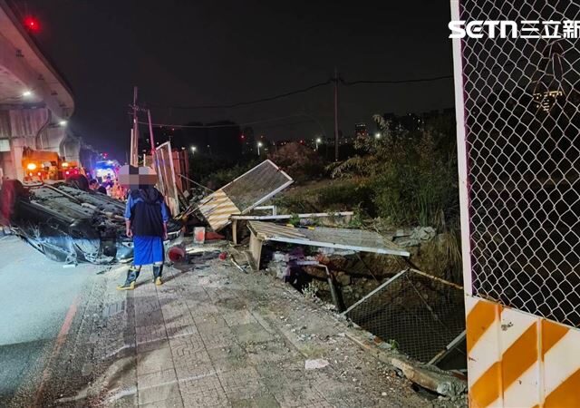 台灣新聞通訊社-新北恐怖車禍！變換車道釀禍…轎車衝破鐵柵「四輪朝天」現場一片凌亂