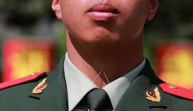 台灣新聞通訊社-一低頭就刺穿？驚見中共解放軍「領口插2針」　台網傻眼：病態的國家