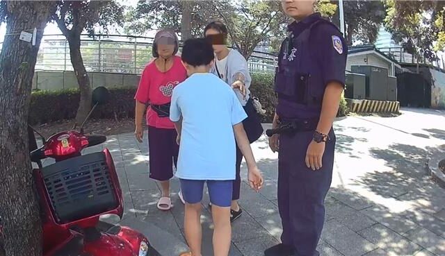 台灣新聞通訊社-老婦電輔車卡花圃動彈不得 警合力抬車救援