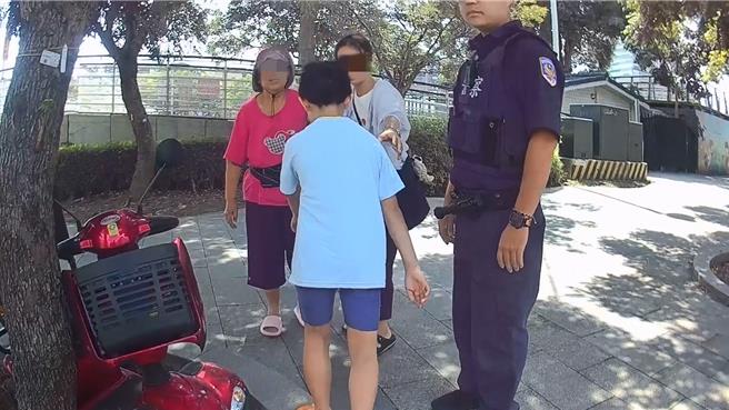 台灣新聞通訊社-老婦電輔車卡花圃動彈不得 警合力抬車救援