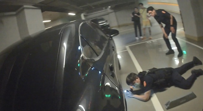 台灣新聞通訊社-民眾車底突傳喵叫聲!萌貓卡底盤狂呼救 6男警著急趴地救援